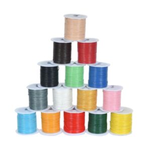Colorful leather cords on spools arranged in a pyramid.