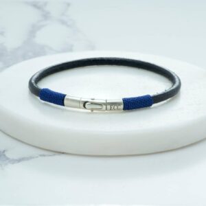 Black leather cord bracelet with blue thread accents and silver clasp.