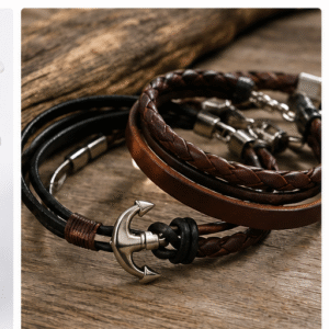 Braided leather bracelets with metal clasps on wooden background 