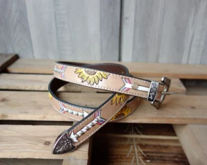 Hand-tooled western leather belt with turquoise accents, silver studs, and engraved metal buckle.