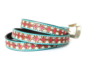Custom leather belts USA with stamped geometric daisy pattern, pink and white hand-painted inlay, and turquoise stitched trim.
